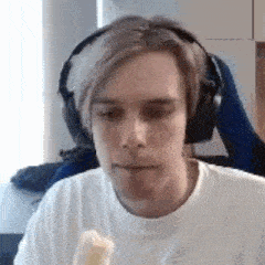 the man is wearing headphones and eating a banana .