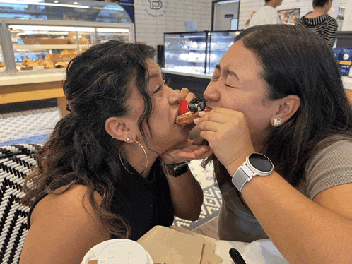 a woman wearing a watch is eating a strawberry
