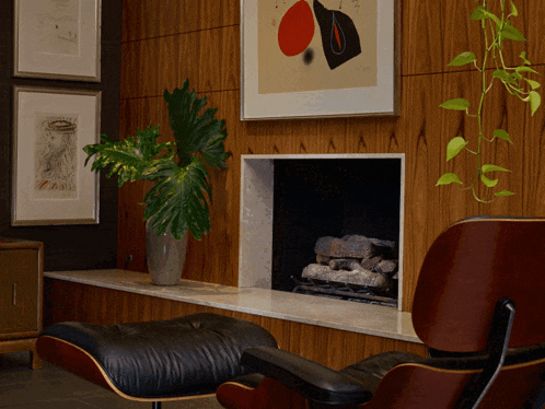 a chair sits in front of a fireplace with a painting above it