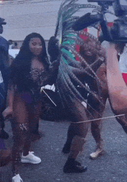 a woman in a feathered costume is dancing in a parade