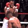 two men are boxing in a ring and one of them is wearing red boxing gloves .