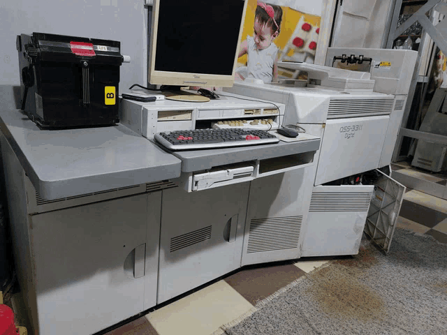 a computer is sitting on a desk next to a printer that says osb-351 on it