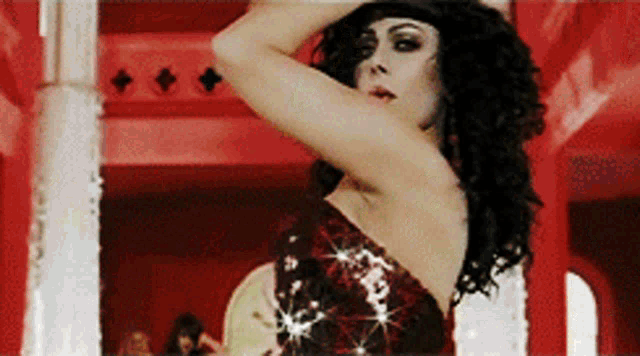 a woman in a red dress is dancing in a red room