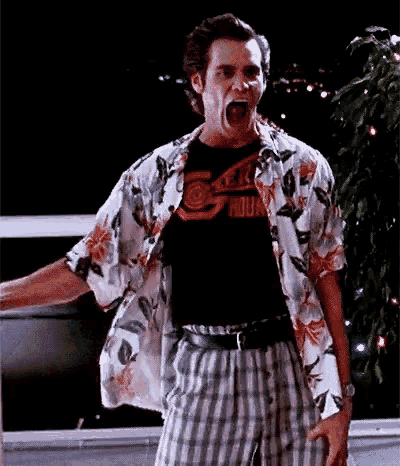 a man wearing a hawaiian shirt and plaid shorts is screaming with his mouth open .