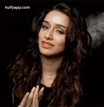 a woman is making a funny face with her hands in the air .