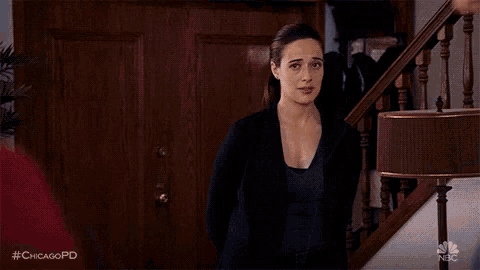 a woman is standing next to a man in front of a door and looking at him .