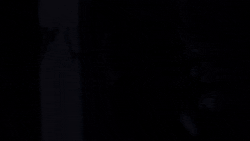 a man in a futuristic suit is standing in a dark room