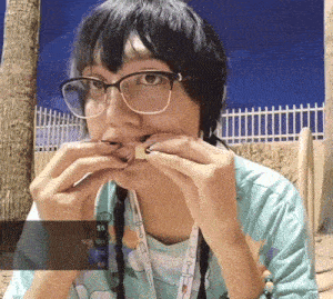 a woman wearing glasses is eating a piece of food with a sticker that says $ 5 on it