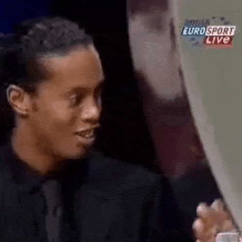 a man in a suit and tie is holding a trophy in front of a eurosport live screen .
