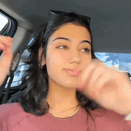 a woman wearing sunglasses is sitting in a car and making a funny face
