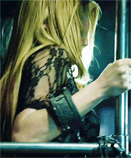 a woman with long blonde hair is wearing a black top
