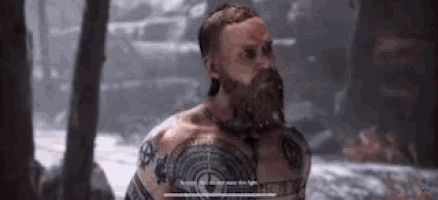 a man with a beard has a tattoo on his chest that says ' ragnarok ' on it