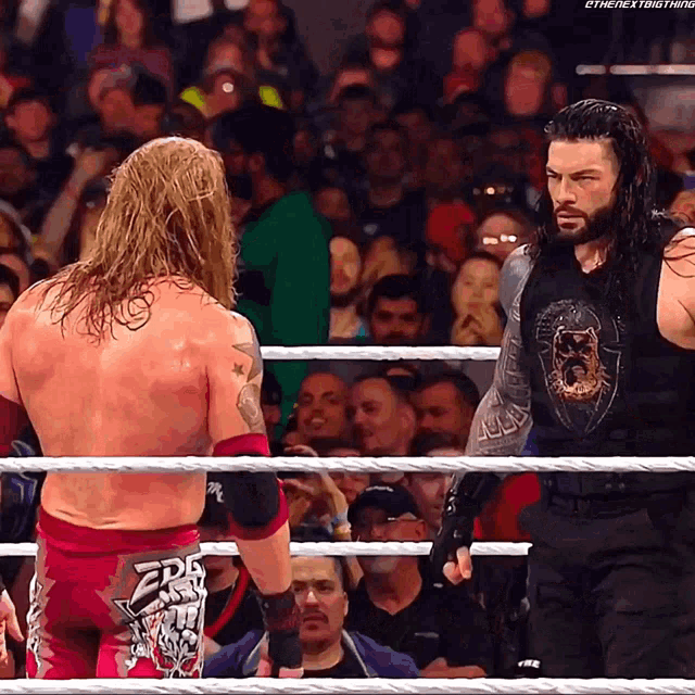 two wrestlers are standing in a ring and one has a shirt that says edge