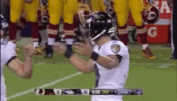 a football player wearing a ravens jersey is standing on a field
