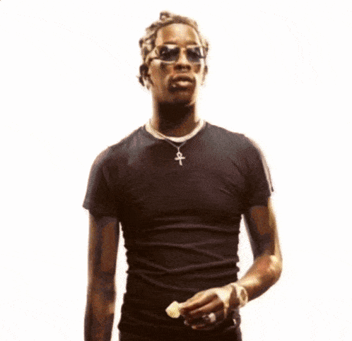 a man wearing sunglasses and a black shirt has an ankh necklace on his neck