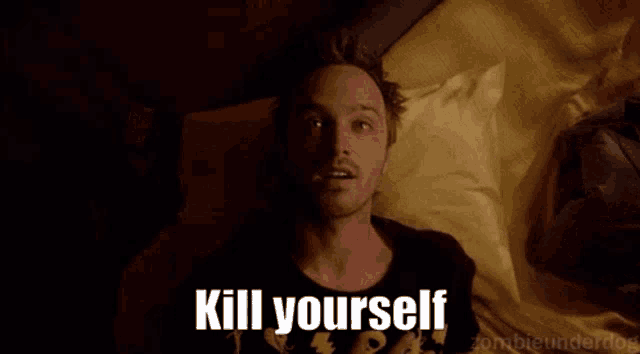 a man laying on a bed with the words kill yourself written on the screen