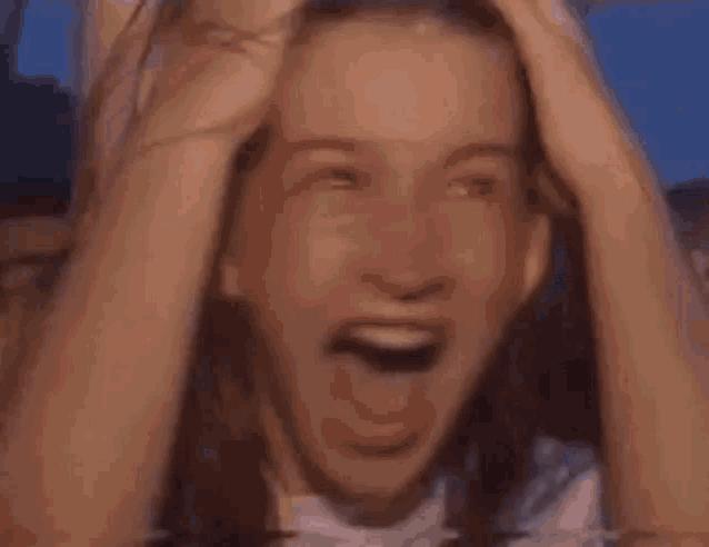 a woman is laughing with her hands together in front of a crowd .