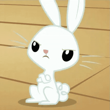 a white rabbit is sitting on a wooden floor and looking at the camera with an angry look on its face .