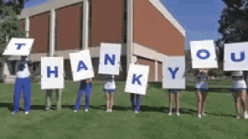 a group of cheerleaders are holding signs that say thank you .