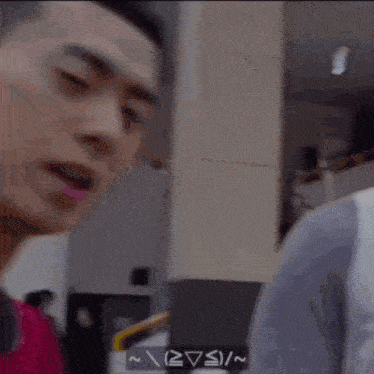 a man in a red shirt is making a funny face with his eyes closed .