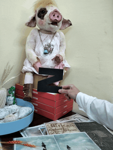 a person holding a letter z next to a stuffed animal