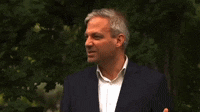 a man in a suit and white shirt is talking to someone
