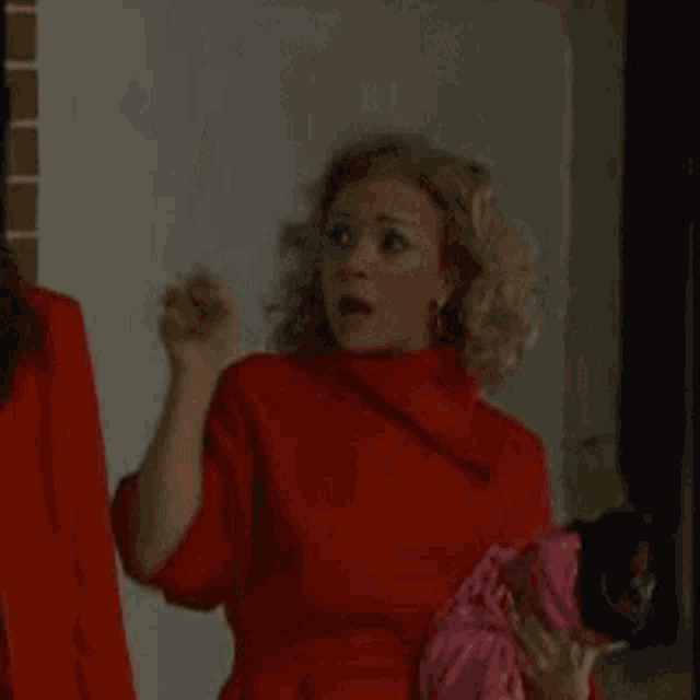 a woman in a red dress is holding a pink hat and says circular .