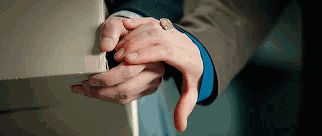a close up of a person 's hands with a ring on their wrist