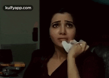 a woman is sitting in a chair with a napkin in her hand .