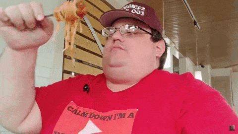 a man wearing a red shirt that says " calm down i 'm a "