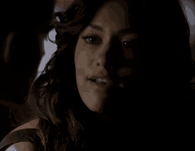 a close up of a woman 's face with a man behind her