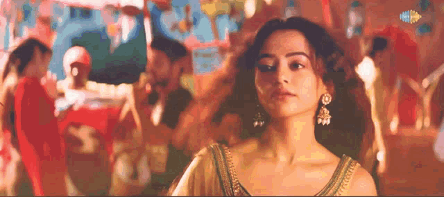 a woman is standing in front of a group of people with a sign that says ' zee music ' on it
