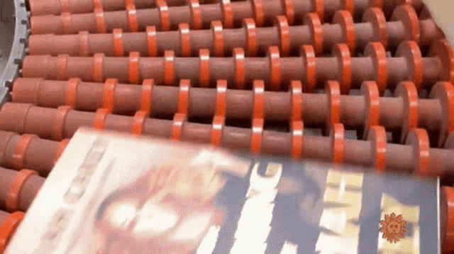 a book is on a conveyor belt with a sun behind it