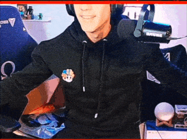 a man wearing headphones and a shure microphone smiles