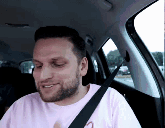 a man with a beard wearing a pink shirt with a heart on it