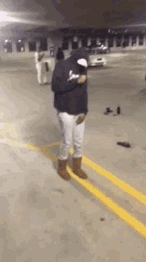 a person in a parking lot with a hoodie on