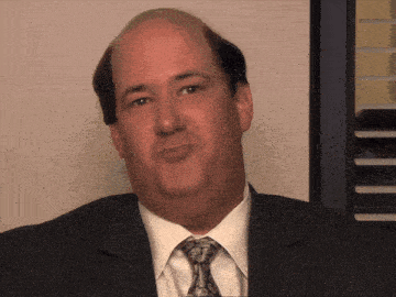 a bald man in a suit and tie is making a face