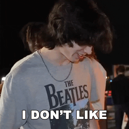 a young man wearing a beatles t-shirt says i do n't like