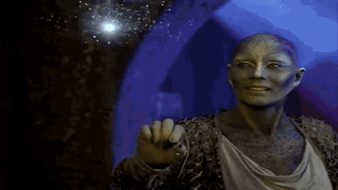 a woman with green paint on her face is reaching for something