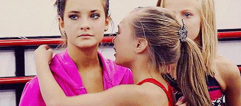 a group of young girls are standing next to each other in a room .