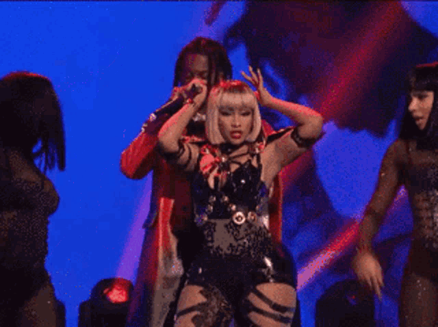 a man in a red coat is standing next to a woman in a black outfit on a stage