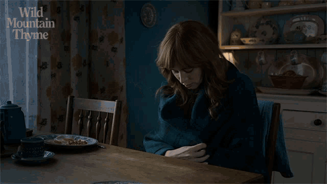 a woman sits at a table with the words wild mountain thyme on the bottom