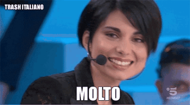 a woman wearing a microphone with the word molto written on it