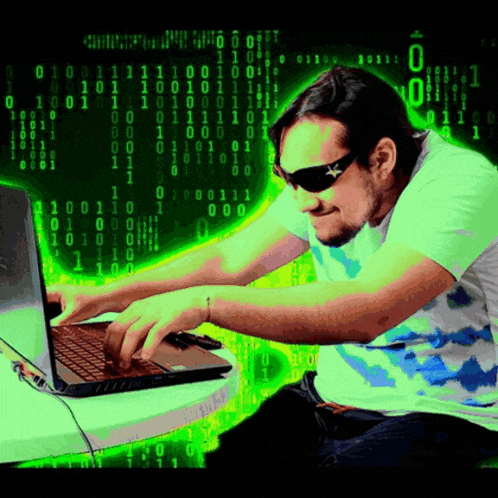 a man wearing sunglasses is typing on a laptop in front of a binary background