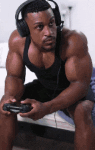a muscular man wearing headphones and holding a video game controller