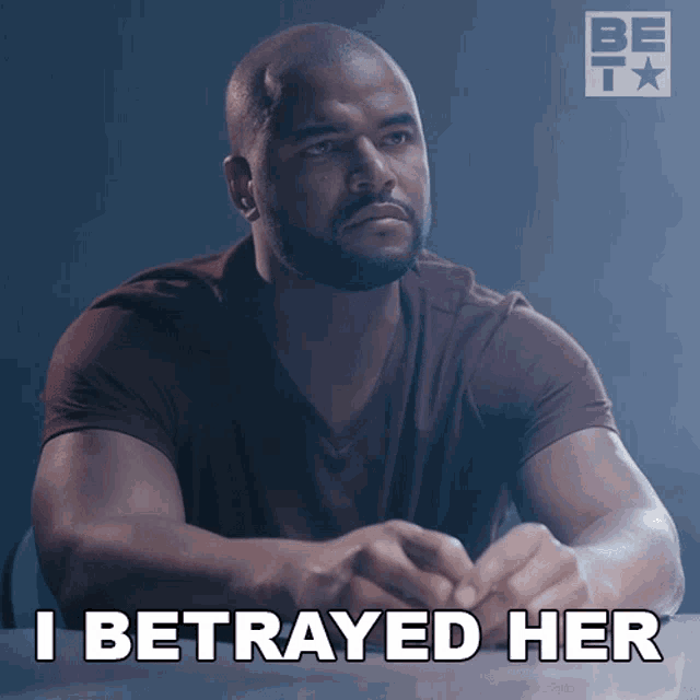 a man sits at a table with the words " i betrayed her " written on the bottom