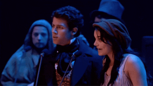 a man and a woman are standing next to each other in a dark room