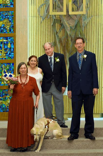 a group of people standing in front of a stained glass window with the word jesus on it