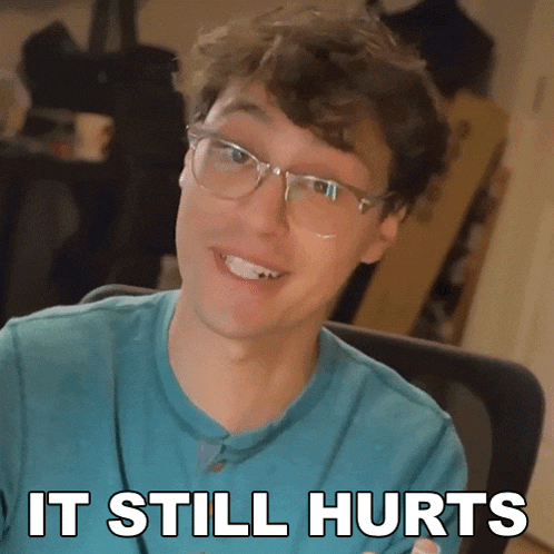 a man wearing glasses and a blue shirt with the words it still hurts below him