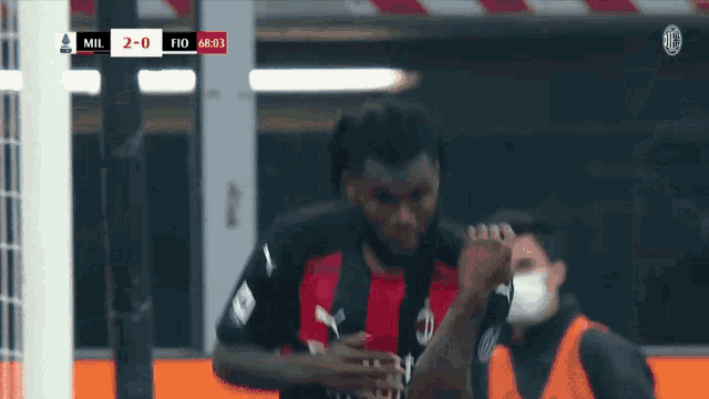 a soccer player celebrates a goal during a game with the score 2-0